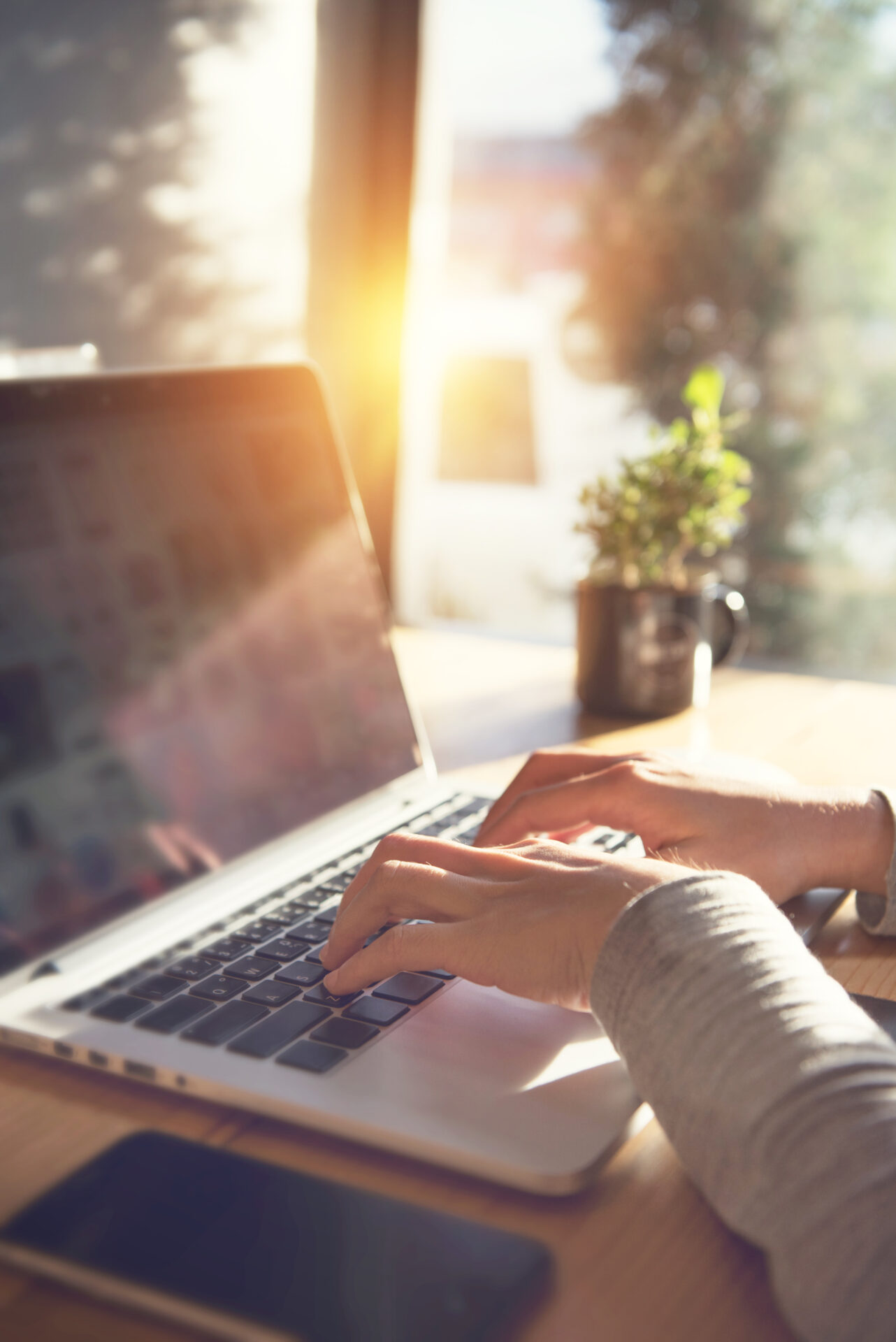 Closeup woman's hands typing on a laptop on a wooden desk with s Gail Harris - Certified Ghostwriter