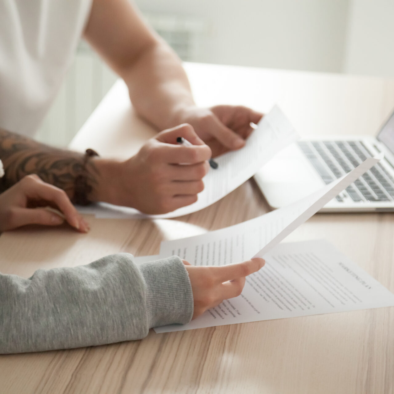 Couple holding reading documents at home with laptop, close up